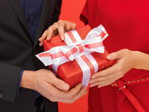 close-up foto van de handen van man en vrouw met geschenkdoos