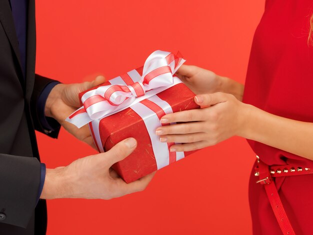 close-up foto van de handen van man en vrouw met geschenkdoos