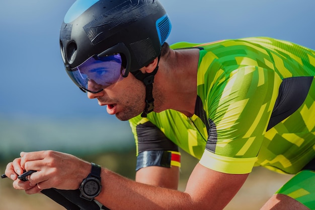 Close-up foto van een actieve triatleet in sportkleding en met een beschermende helm op de fiets. Selectieve focus.