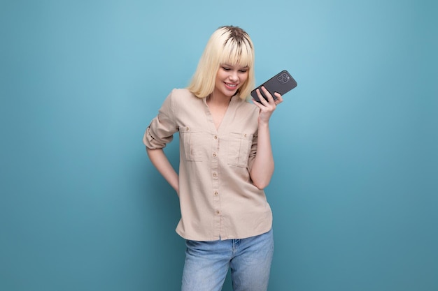 Close-up foto van een charmante Europese blonde vrouw die aan de telefoon chat