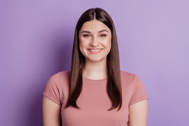 Close-up foto van een mooie, aantrekkelijke meid met brede glimlach en casual kleding die over een violette kleurachtergrond wordt geïsoleerd