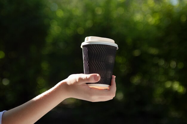 Foto close-up foto van een vrouw die een kop koffie in de hand houdt plaats voor logo