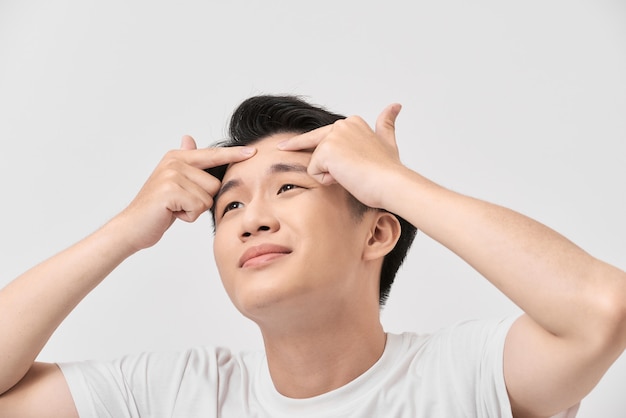 Close-up foto van jonge man op zoek naar acne op zijn gezicht