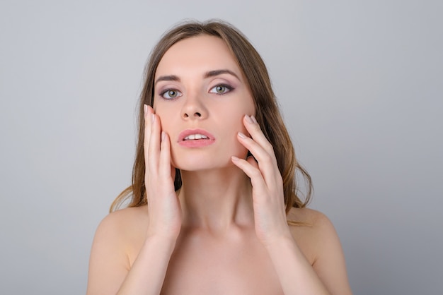 Close-up foto van jonge vrouw gezicht aan te raken