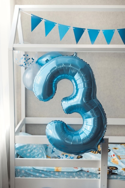 Close-up foto van schattig huis bed huis in de kinderkamer versierd met blauwe ballonnen voor 3 jaar oud