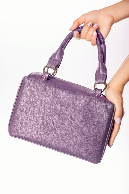 Foto close-up foto van trendy violet tas in handen van modieuze vrouw