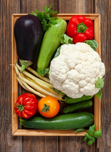 Close-up foto van verse biologische groenten en groen van de boerderij. Bovenaanzicht op houten achtergrond