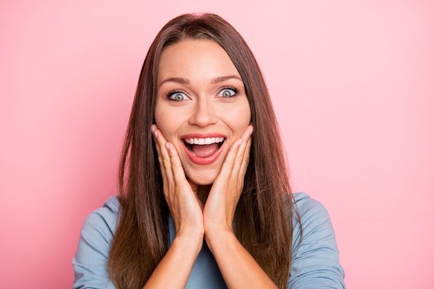 Close-up foto van vrolijke positieve schattige mooie mooie vriendin glimlachend toothily emoties uitdrukken op gezicht in blauwe trui geïsoleerd roze pastel kleur achtergrond