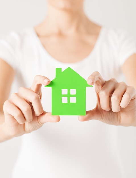 close-up foto van vrouw handen met groen huis