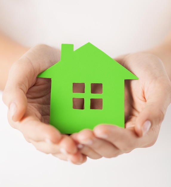 close-up foto van vrouw handen met groen huis