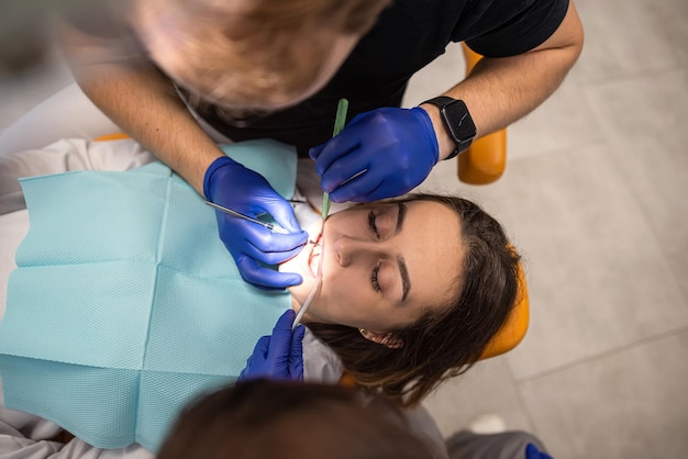 Foto close-up foto van vrouw met open mond met spiegel voor tandheelkundige apparatuur