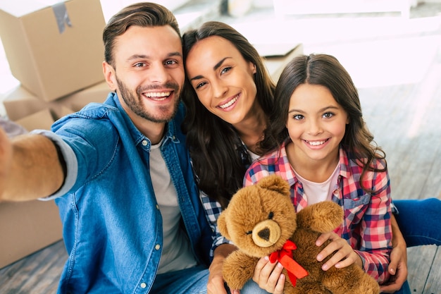 Close-up foto, vrolijke familie neemt samen selfie in hun nieuwe huis voor een stapel kartonnen dozen