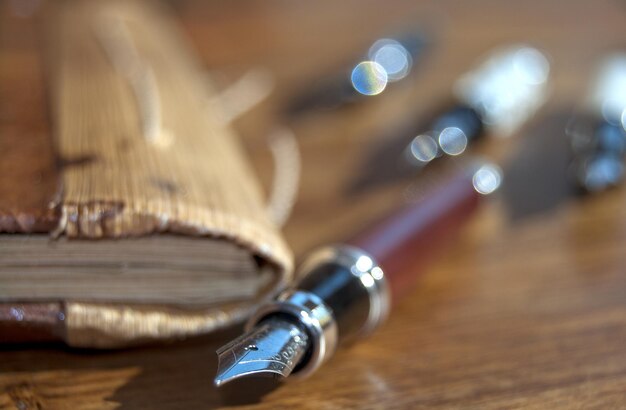 Close-up of fountain pen by book on table