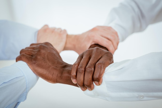 Close-up of a four black and white hands holding together tightly.