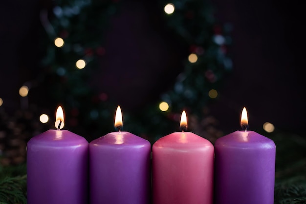 Photo close-up of four burning purple advent candles.