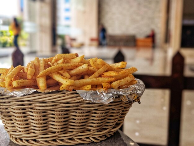 Foto close-up di patatine fritte in cesto di vimini sul tavolo