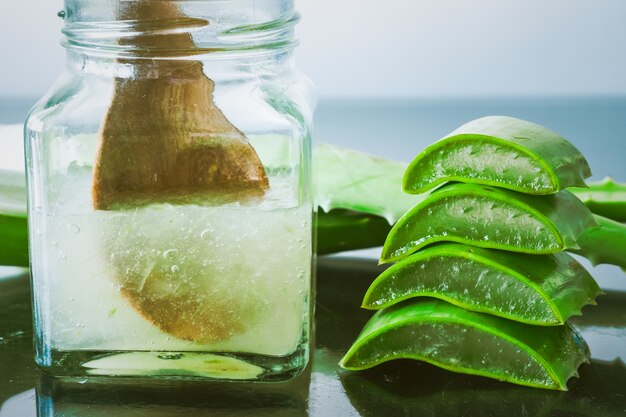 Close up of Fresh aloe vera and jelly in glass bottle