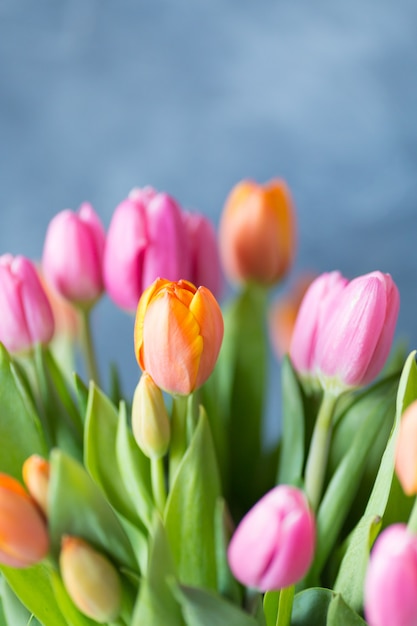 꽃병에 핑크 장미 오렌지 튤립의 신선한 꽃다발 무리 닫습니다.