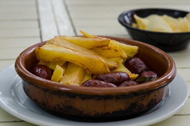 Photo close-up of fresh chorizo with fried potatoes served in plate