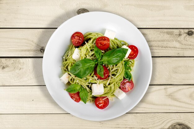 Primo piano della deliziosa pasta italiana fresca in piatto bianco su fondo di legno