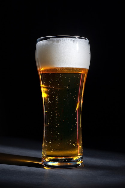 Close up of a fresh glass of beer with foam