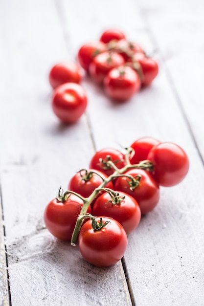 Close-up fresh grape tomatoes on wooden board.