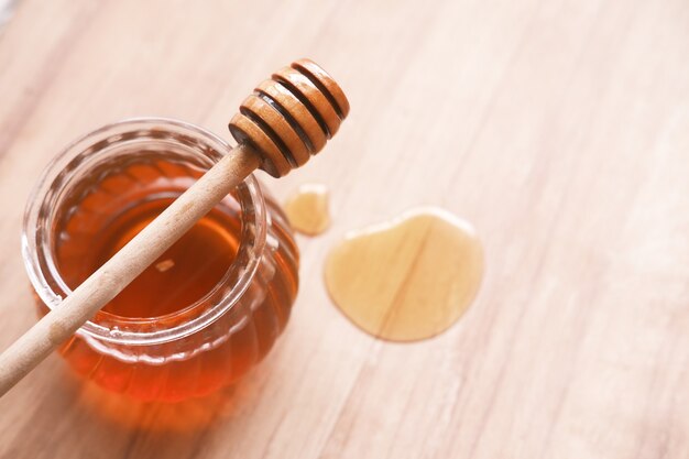 Close up of fresh honey with spoon on table