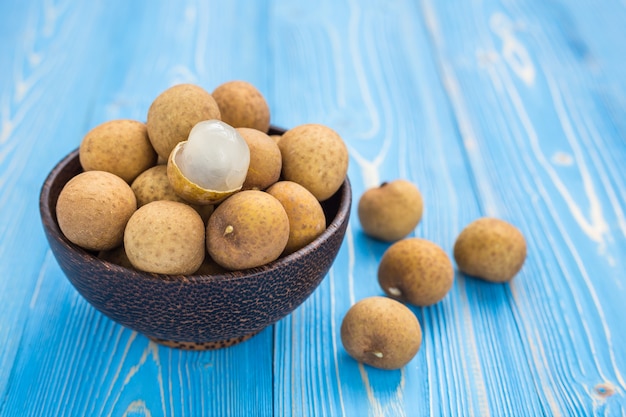 Close up fresh longan tropical fruit on blue wooden plank background