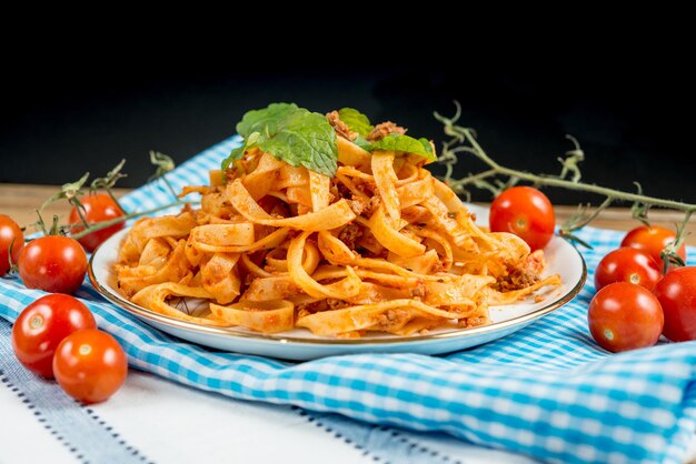 Close-up of fresh meal served in plate on napkin against black background