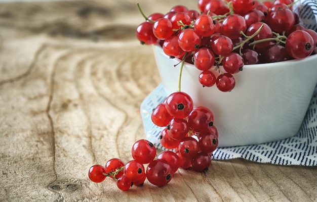 Close up of fresh red currants on wooden table