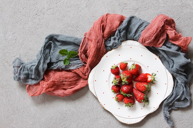 Close-up of fresh red strawberries on white plate 