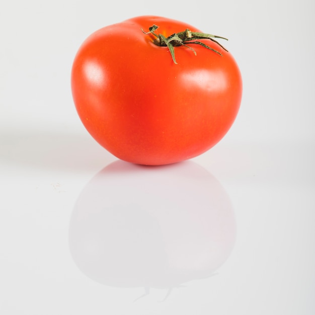 Foto primo piano di un pomodoro rosso fresco su sfondo bianco