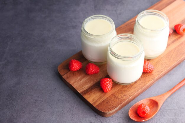 close up of fresh yogurt in a bowl on wooden background