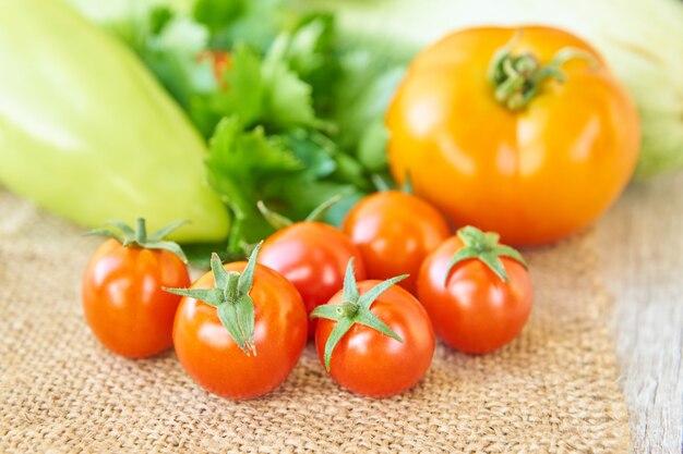 Close up of freshly pickled harvest of vegetbles - bell pepper, drill and tomatoes on wooden table. Rustic style. Organic healthy food concept with copy space