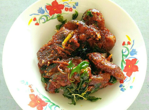 Photo close-up of fried fish in plate on table