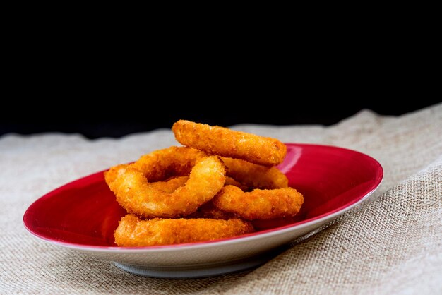 Foto close-up di cibo fritto in piatto su sfondo nero