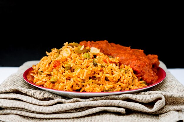 Photo close-up of fried rice with curry on table against black background