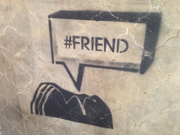 Foto close-up di graffiti di testo di un amico sul muro