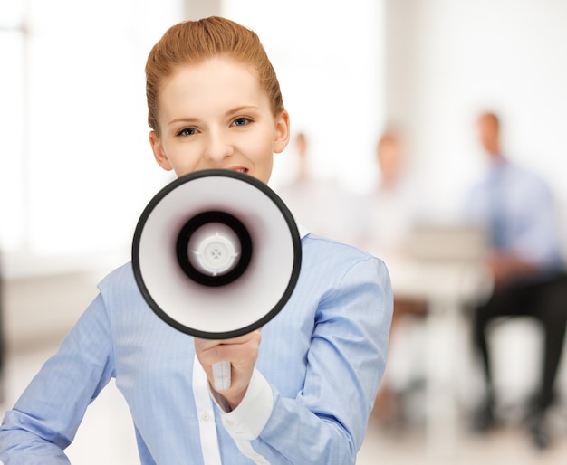 close up of friendly businesswoman with megaphone in office