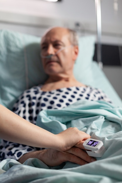 Close up of friendly doctor hands holding patient hand