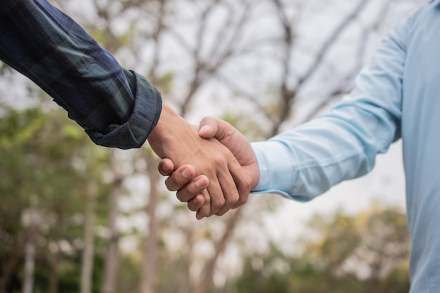 Close up friends shake hands friendship partner community