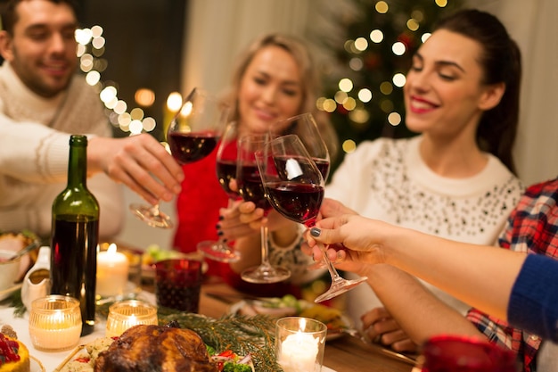 close up of friends with wine celebrate christmas