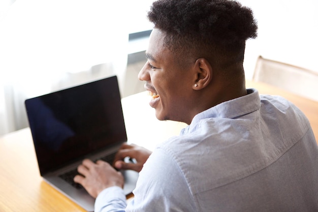Close up from behind of african american man working with laptop