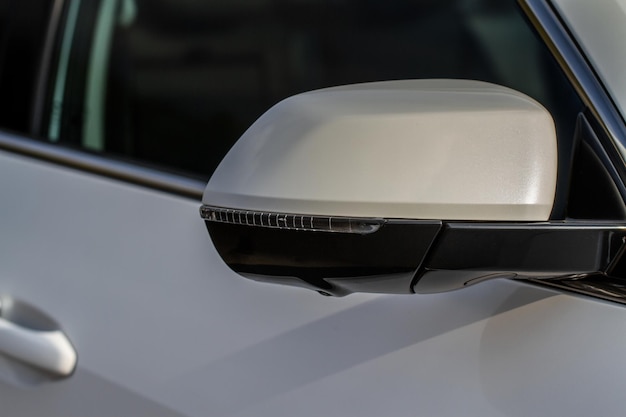 Close up front view of car side mirror. front rear view mirror
on the car window. car exterior details. white car mirror.