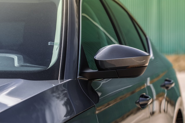 Close up front view of car side mirror. Front rear view mirror on the car window. Car exterior details.