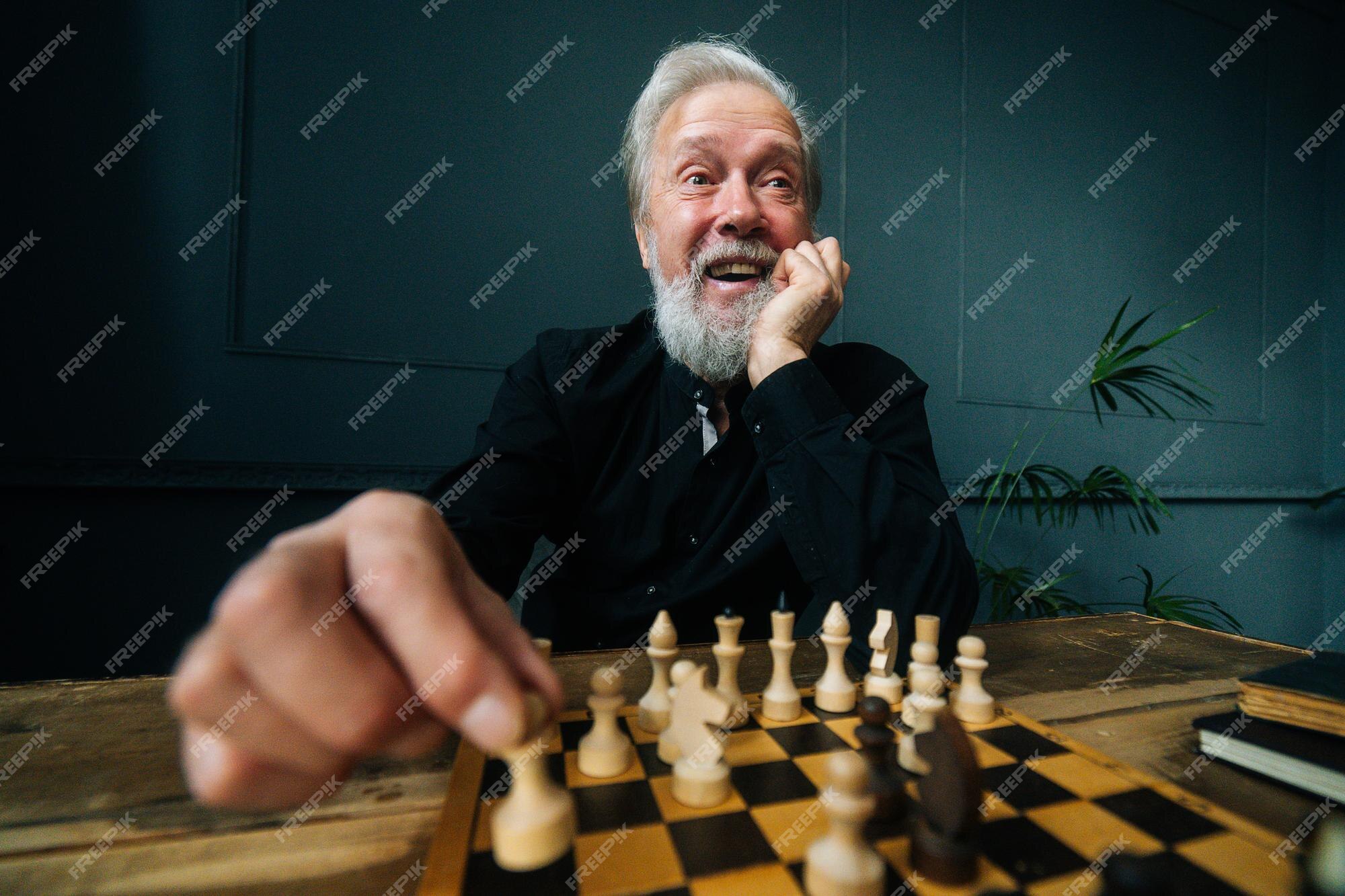 Premium Photo  Young bearded man in sunglasses sitting on a wooden park  bench planning his next chess move