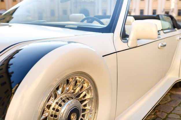 Close-up of the front of a white vintage car in the courtyard of the castle.