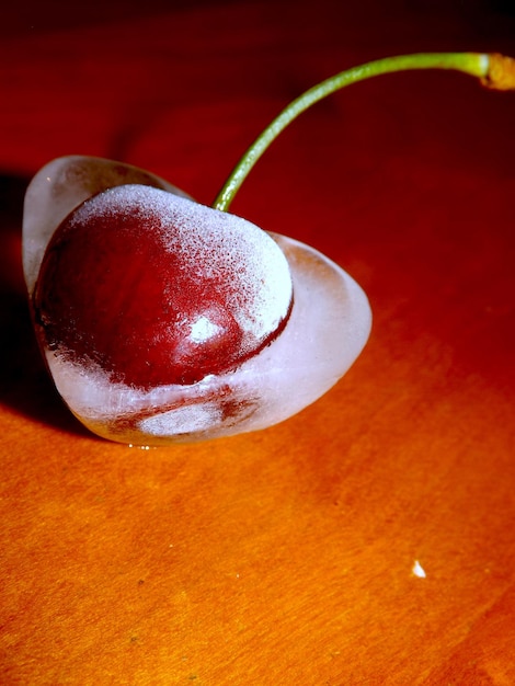 Photo close-up of frozen cherry on table