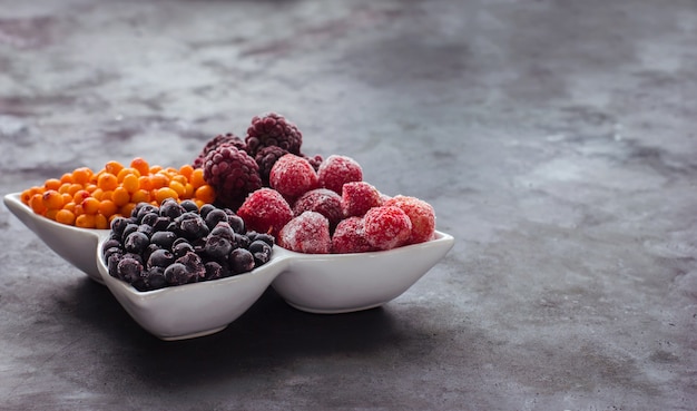 Close up of frozen mixed fruits and berries on a black table  Healthy food vitamins snack dessert