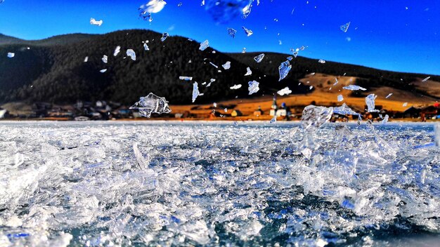 Close-up of frozen river against blue sky